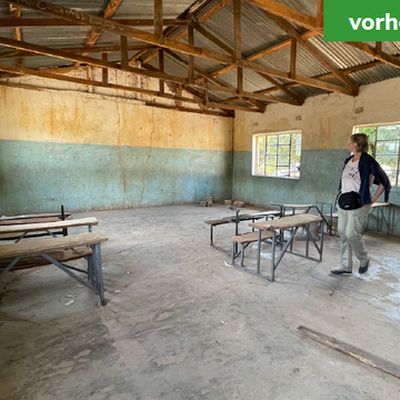 A deserted, empty classroom with damaged walls and old benches. Labeled 'before'.