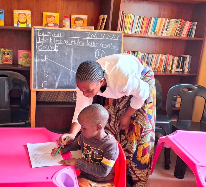 Ein Kind lernt mit einer Betreuerin in der Natubelenge Children’s Library