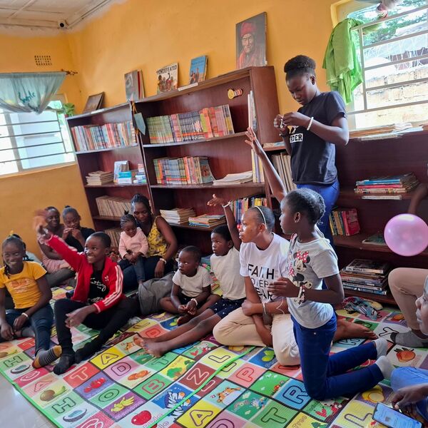 Kinder lesen auf bunten Matten in der Natubelenge Children’s Library