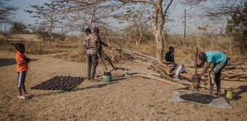 Menschen in Sambia stellen mit einfachen Mitteln Briketts aus verkohlten Pflanzenresten her